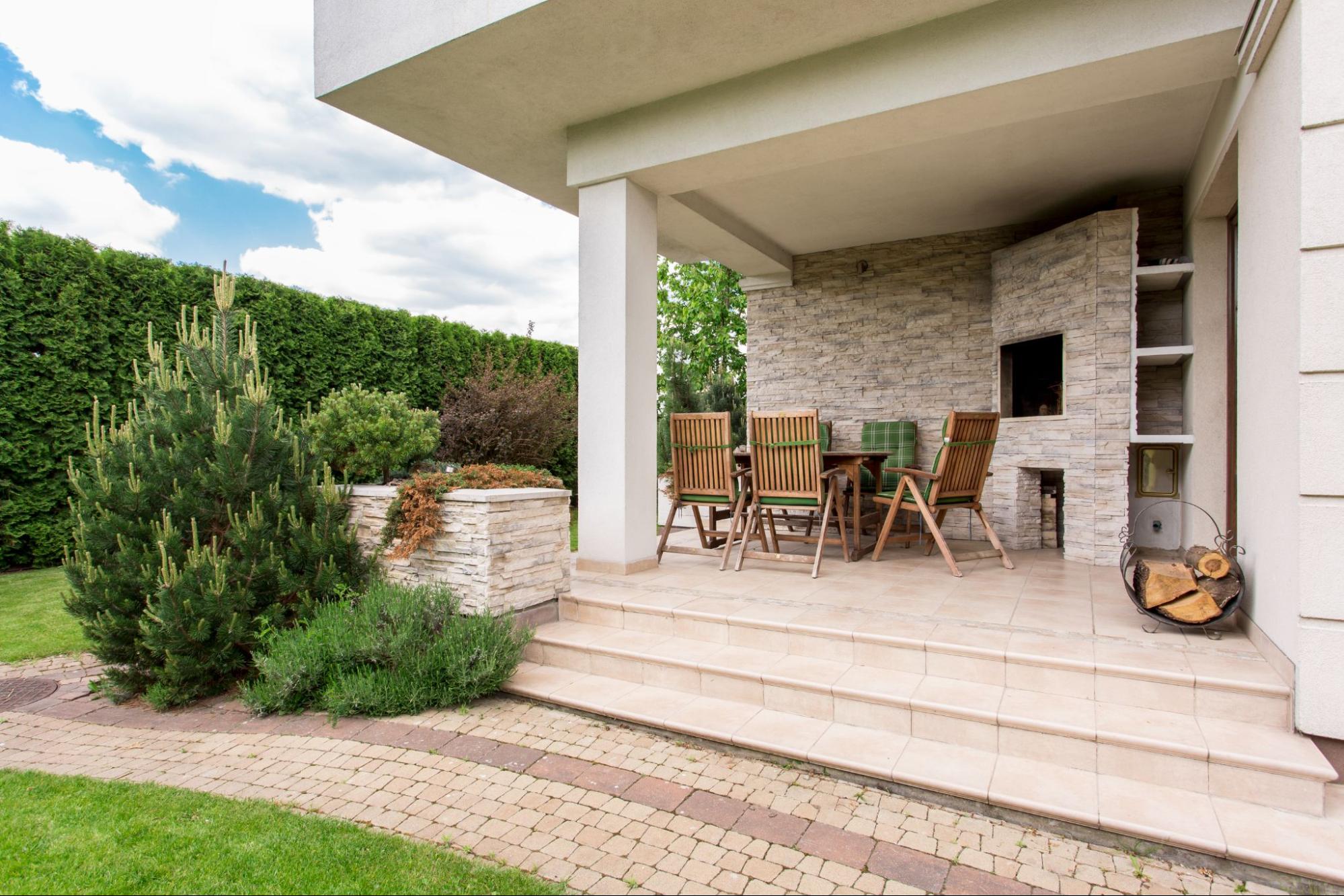 Home with concrete work and shrubbery.