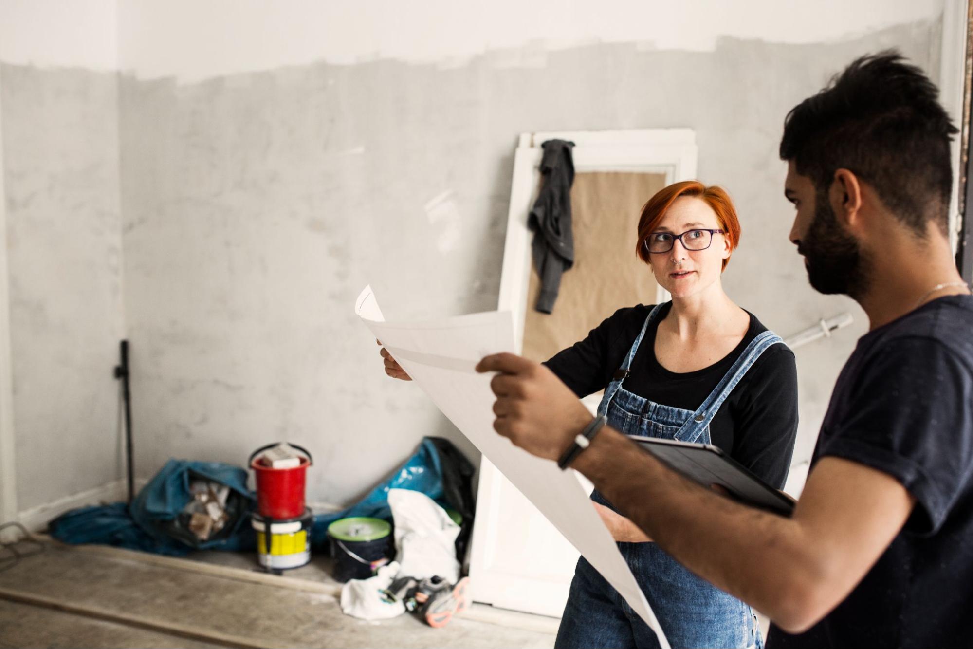 Man and a woman looking at a blueprint.